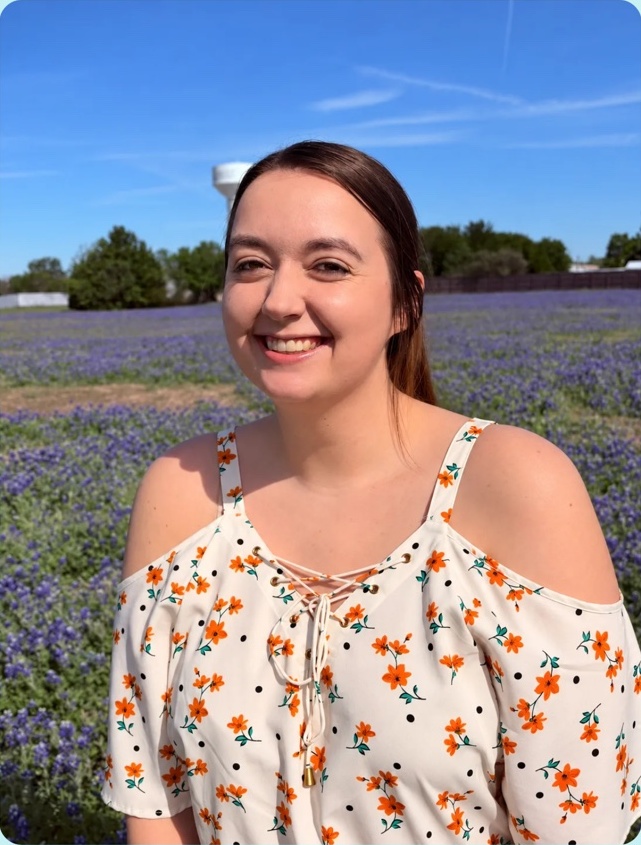 Ginger smiling in a field of bluebonnets